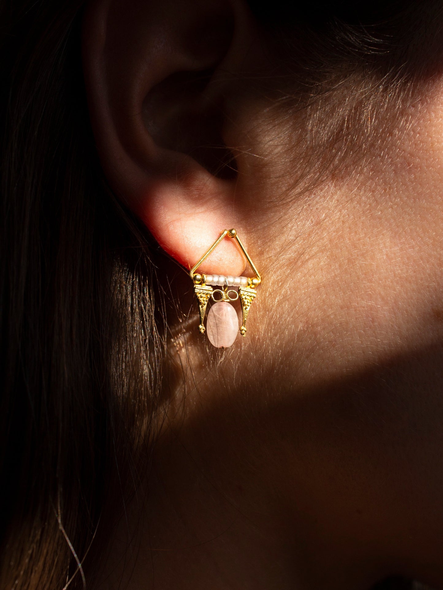 Gold pink quartz earring in dramatic light