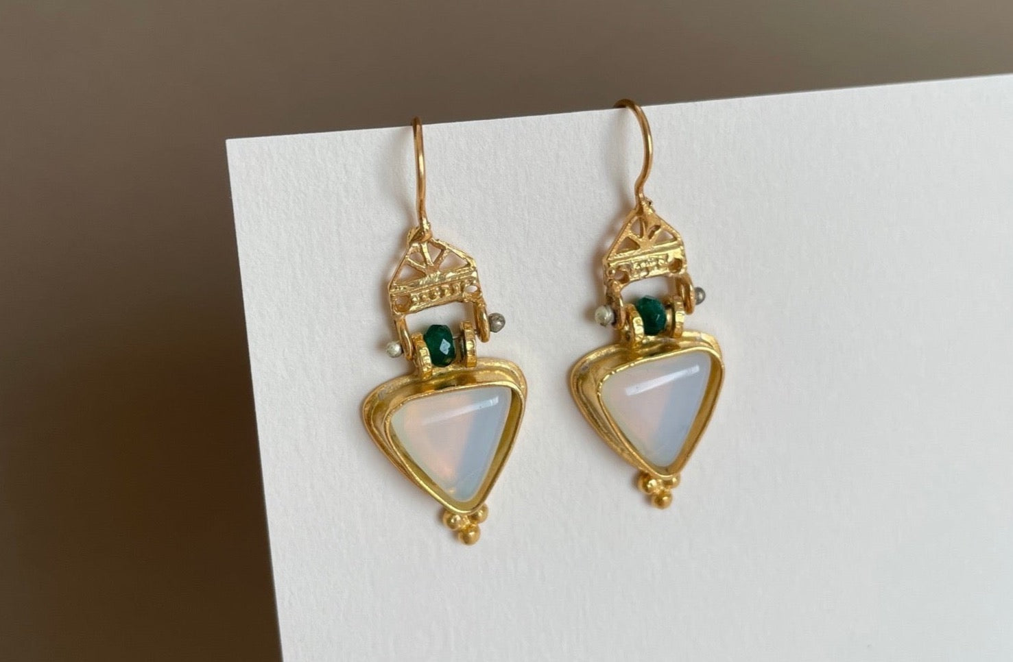 Close up Photo of Asteria Earring, moonstone framed with gold and malachite gemstone