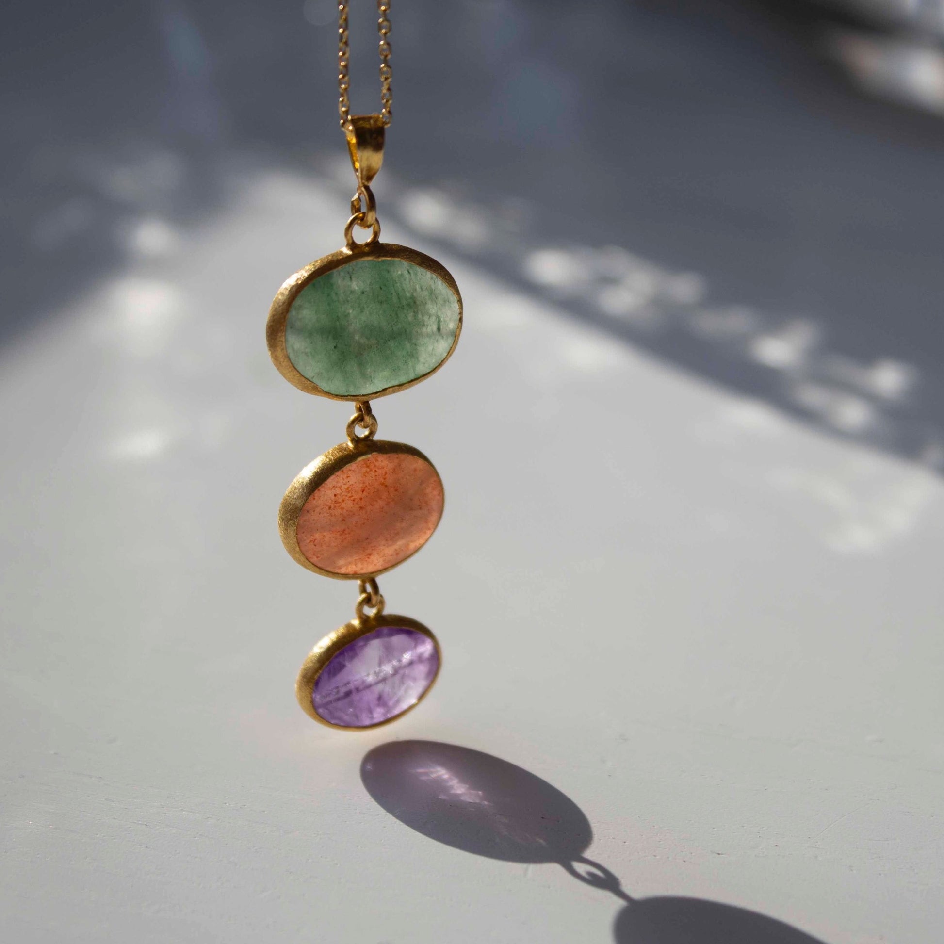 Green aventurine, pink moonstone and amethyst creating a harmonious pendant, Charites
