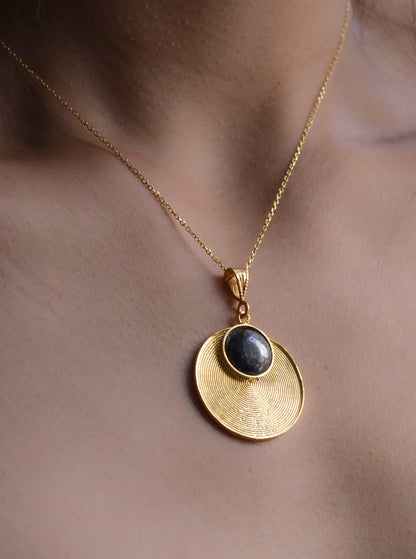 Eclisse necklace gold spiral shaped necklace with a oxidised silver circle