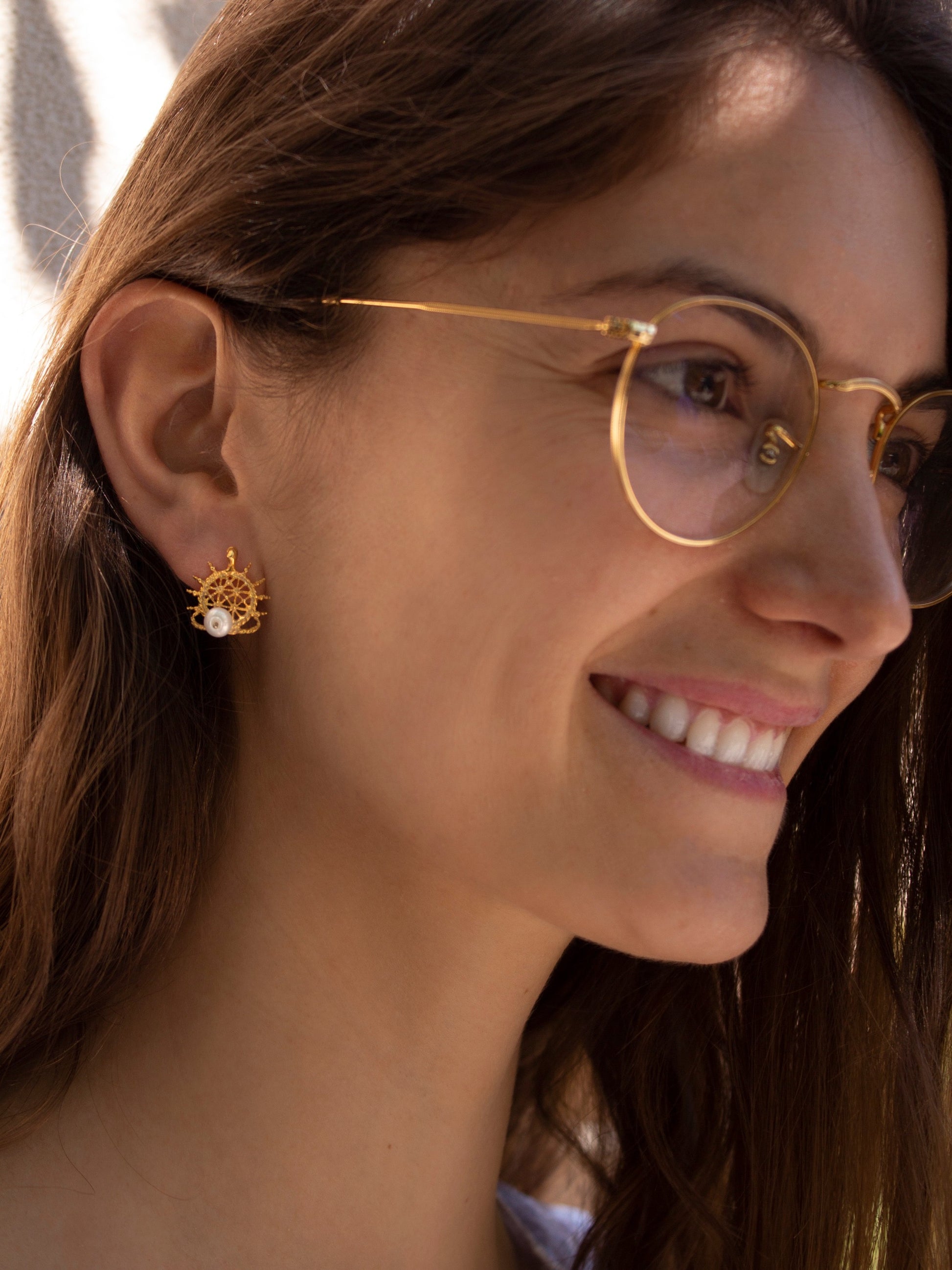 Girl wearing gold Hittite sun earrings with pearl