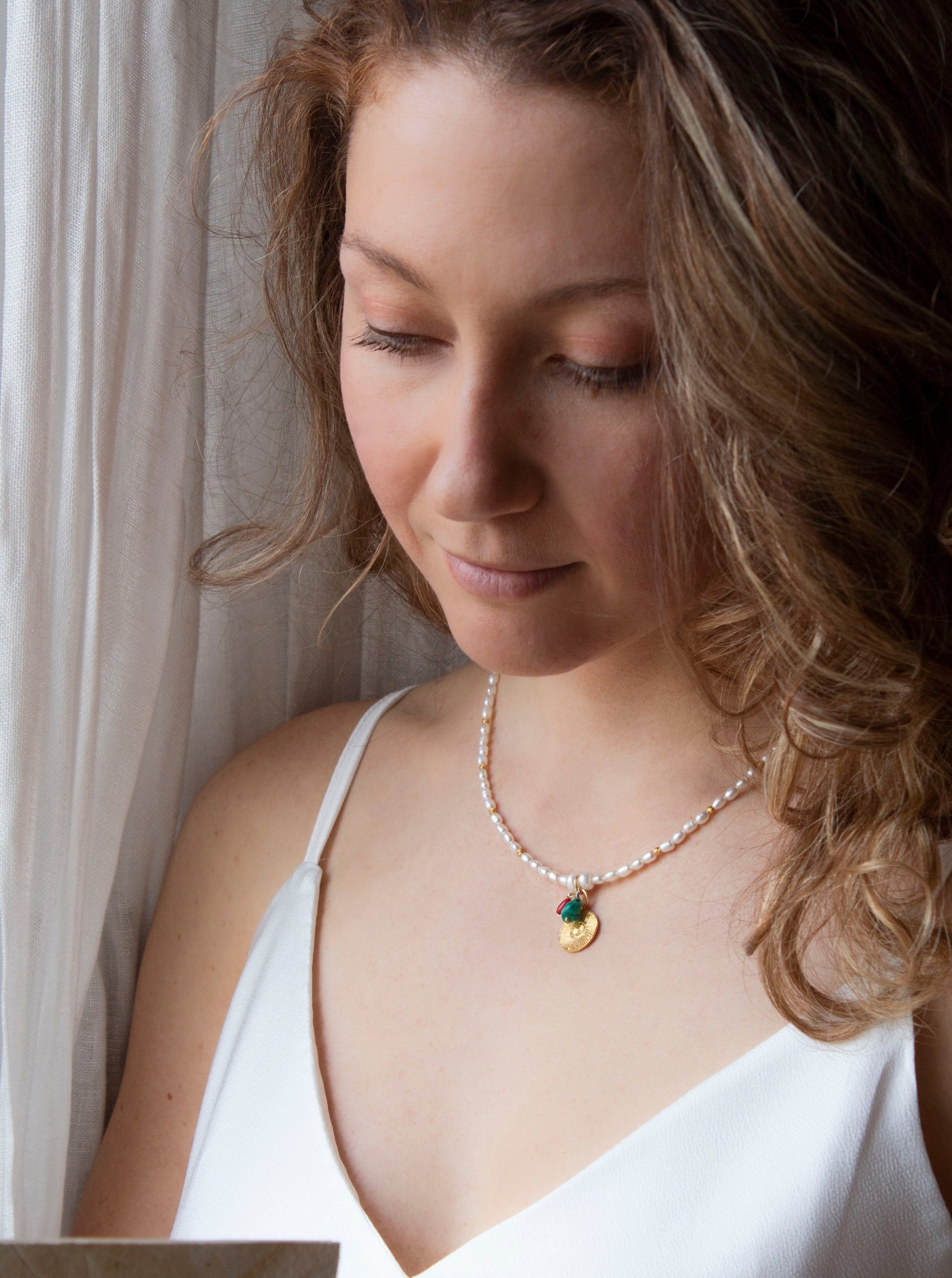 Pearl necklace with turquoise, pearl and a gold sun coin pendant 